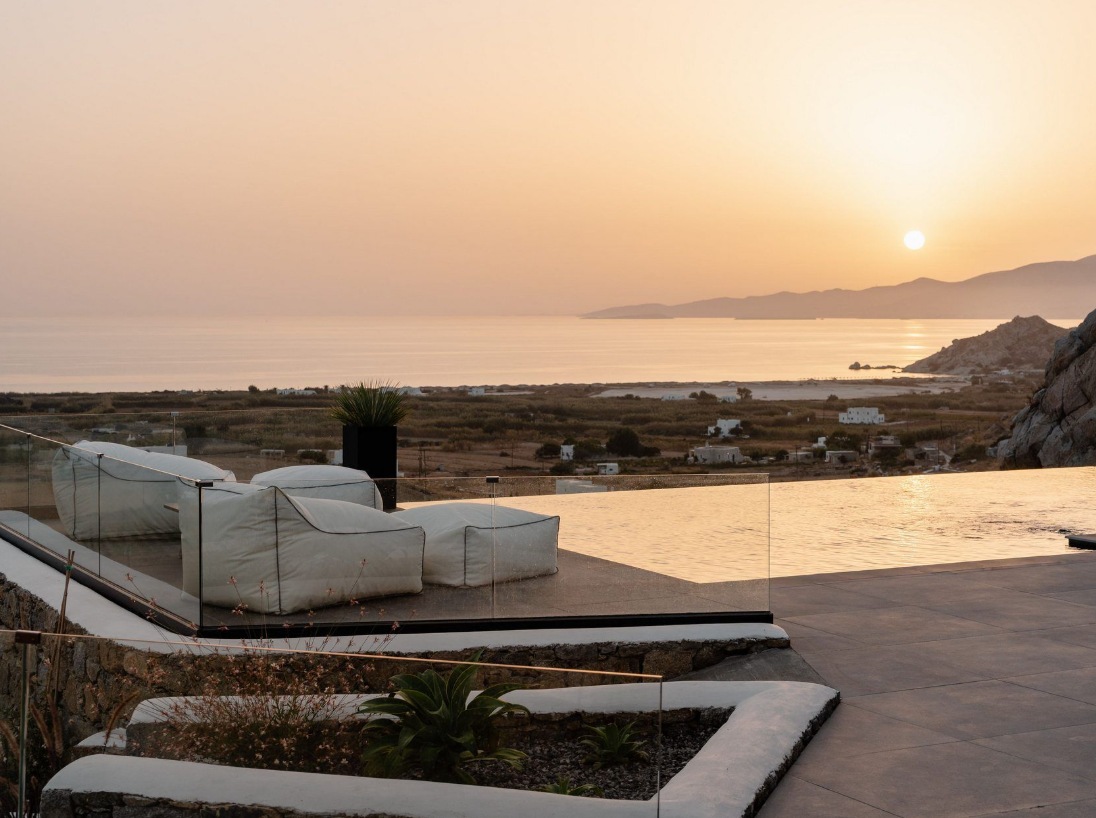 The villa infinity pool and lounge cushions at sunset, looking over the Naxos coast