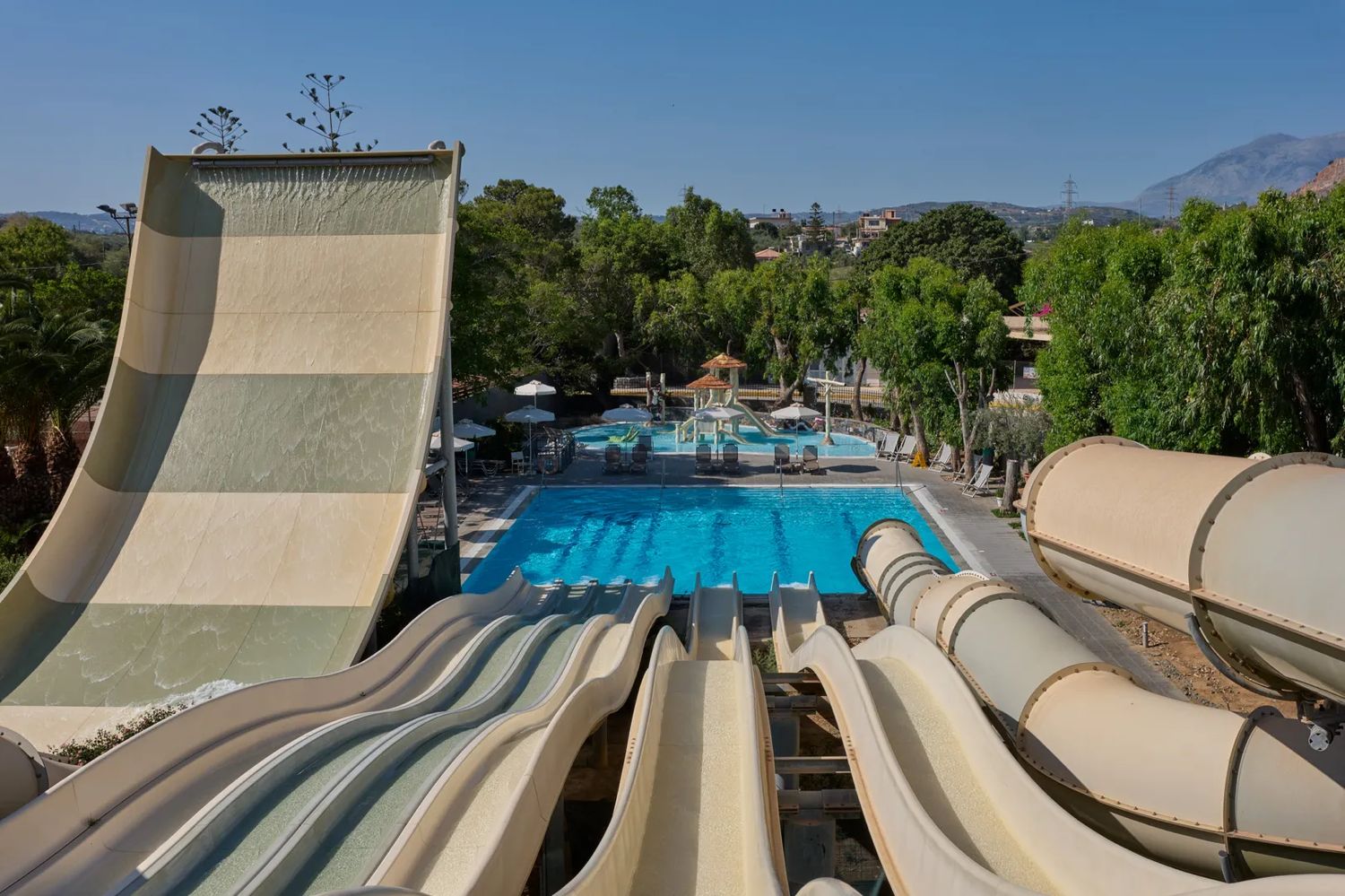 Looking down the resort's tall waterslides toward a blue pool and a children's splash area